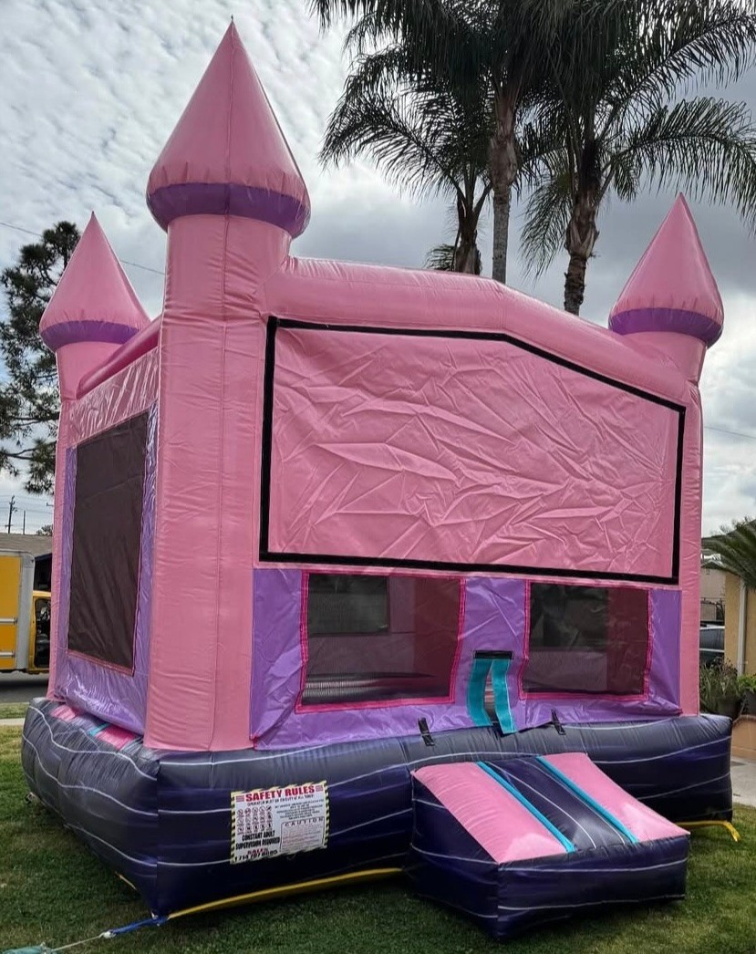 Pink inflatable castle bounce house with turrets and flags