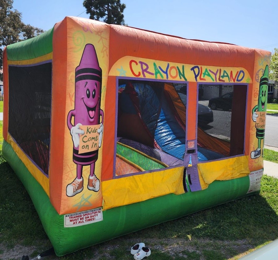 Colorful crayon-themed bounce house jumper with vibrant design elements.