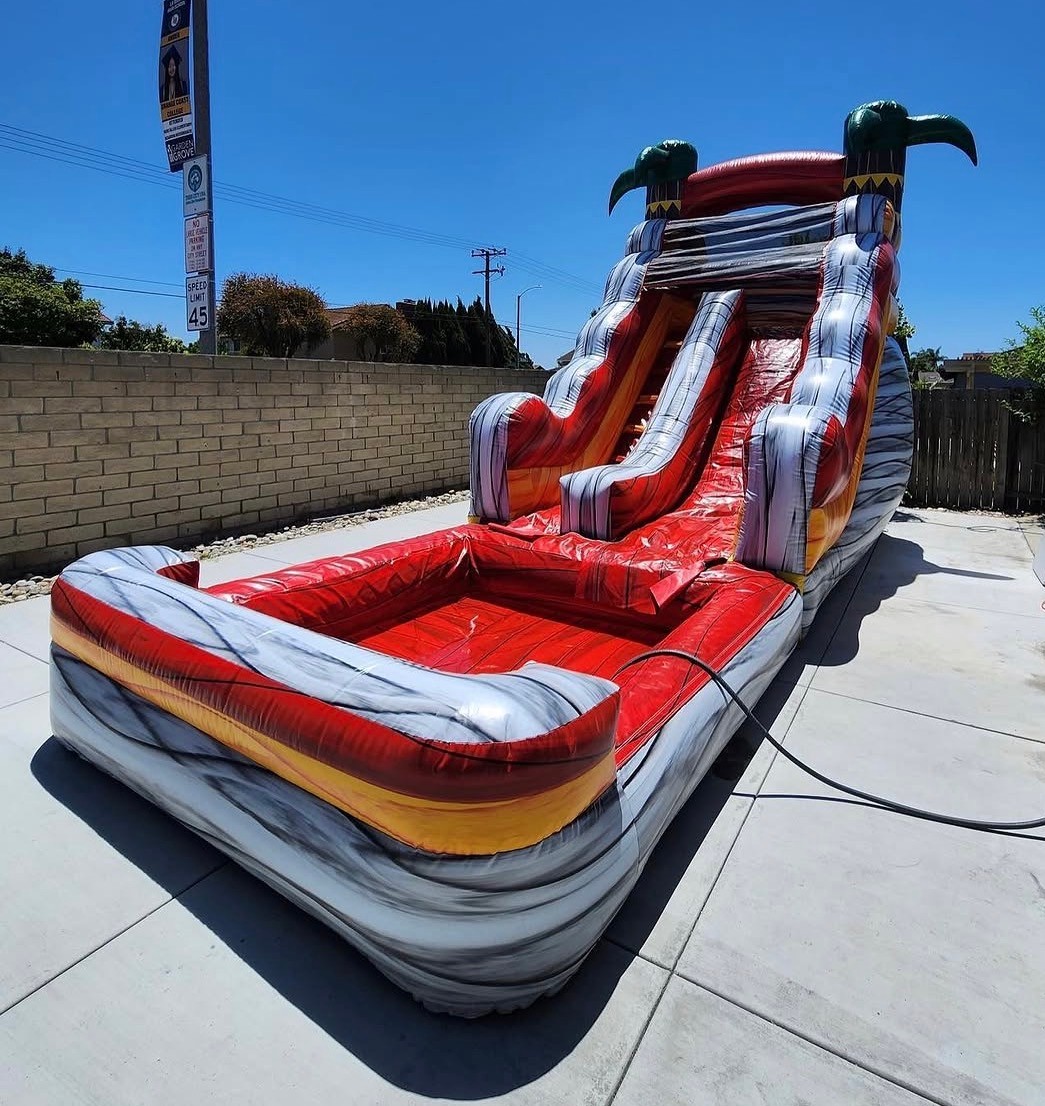 Tropical themed water slide inflatable with grey, yellow, and red colors from another view