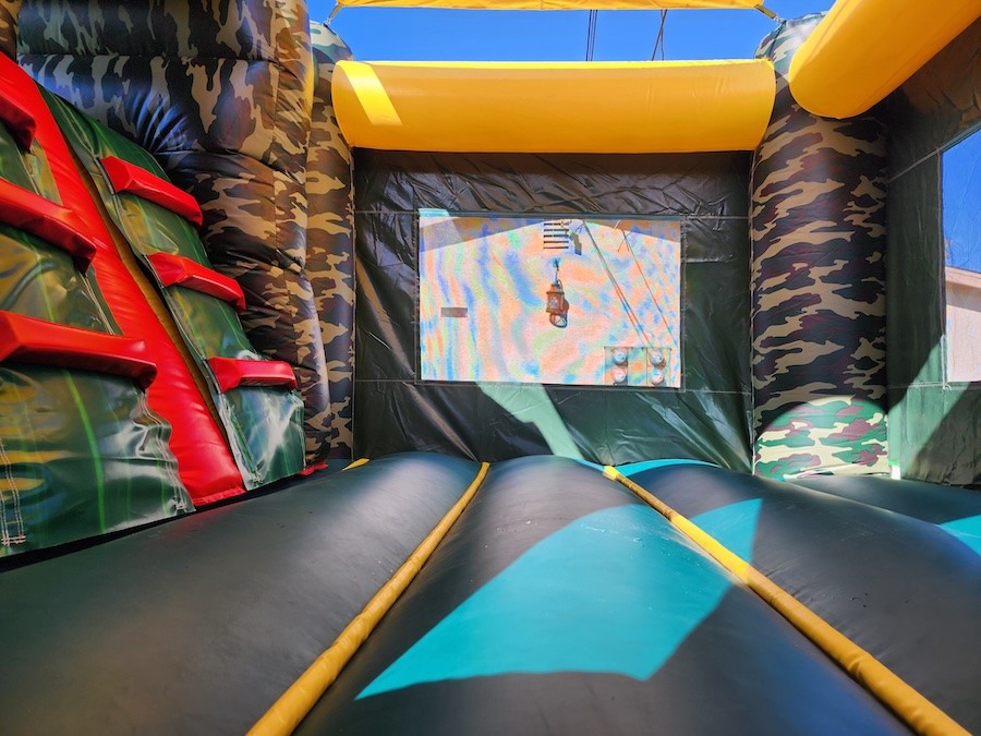 Camouflage-themed combo bounce house with jumping and play areas